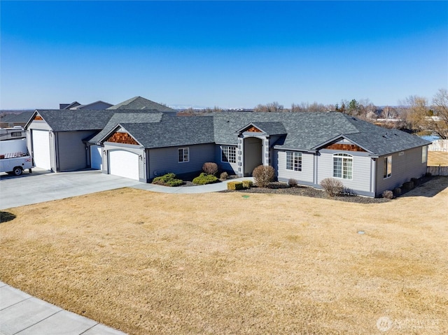 view of front of house featuring an attached garage, a front lawn, and concrete driveway