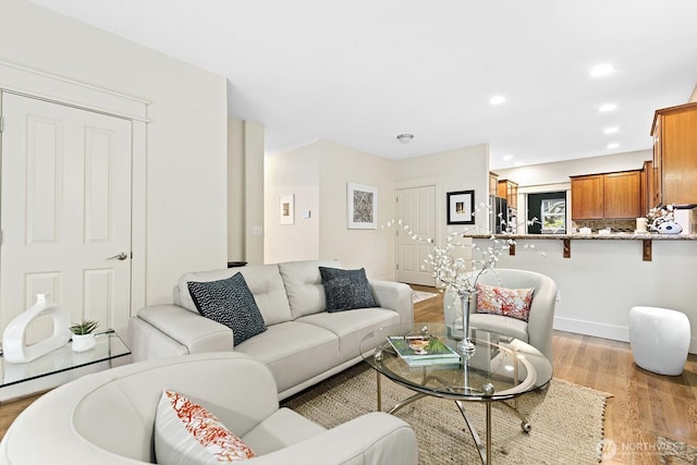 living area with recessed lighting and light wood-style flooring