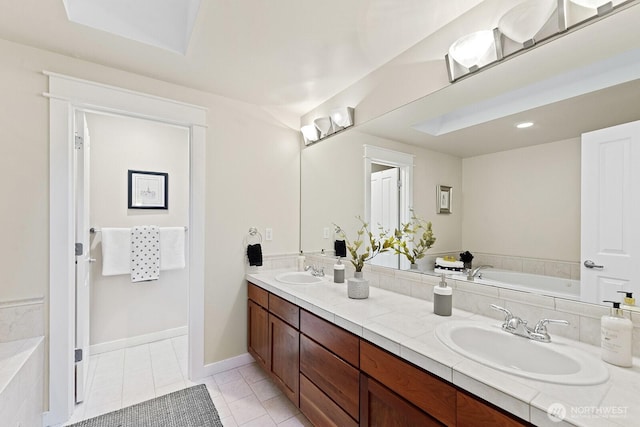 full bath featuring a bath, double vanity, a sink, and tile patterned floors