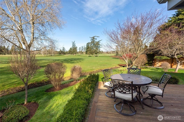 deck with a yard and outdoor dining space