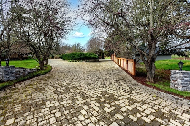 view of home's community with a yard and fence