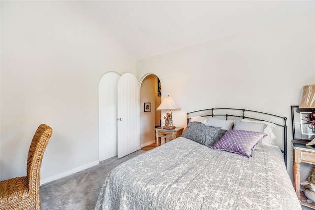 carpeted bedroom featuring lofted ceiling and baseboards