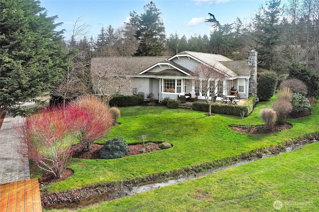 ranch-style house featuring a chimney, fence, and a front lawn