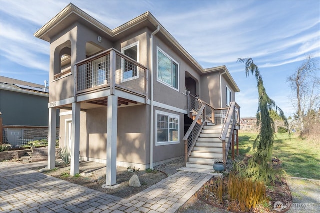 view of front of home with stairway and stucco siding