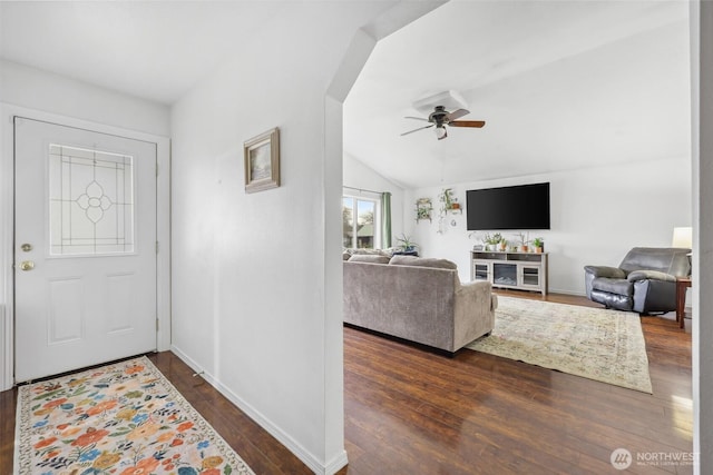 foyer entrance featuring dark wood-style floors, ceiling fan, baseboards, and vaulted ceiling