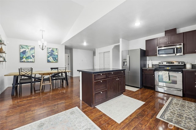 kitchen with appliances with stainless steel finishes, dark countertops, dark wood finished floors, and dark brown cabinetry