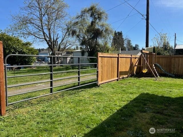 view of yard featuring fence and a playground