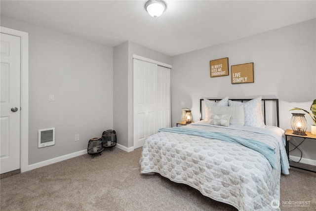 carpeted bedroom featuring a closet and baseboards