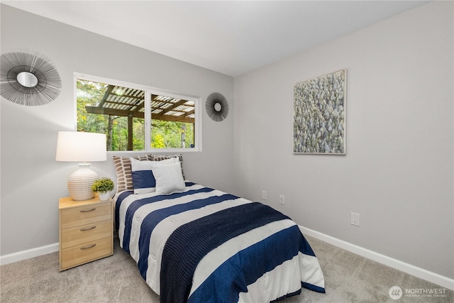 bedroom featuring light carpet and baseboards