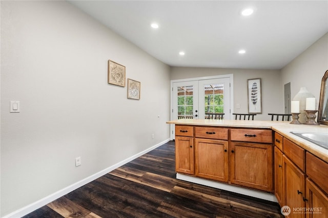 kitchen with lofted ceiling, light countertops, french doors, and dark wood-type flooring