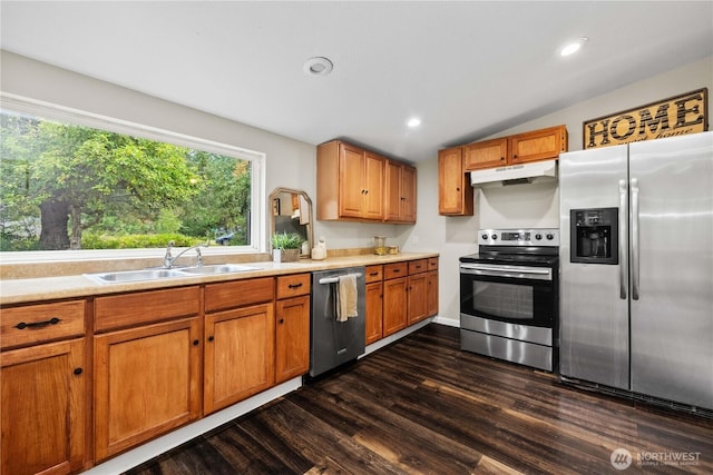 kitchen with appliances with stainless steel finishes, light countertops, a sink, and under cabinet range hood