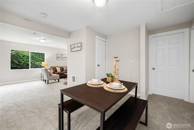 carpeted dining area featuring baseboards