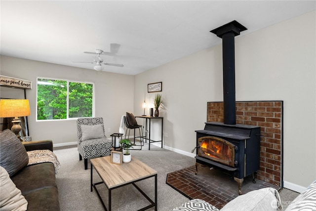 carpeted living room featuring a ceiling fan, a wood stove, and baseboards