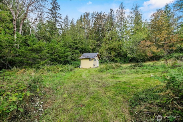 view of yard featuring a storage shed and an outbuilding