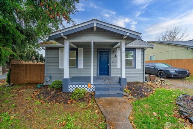 bungalow-style home with fence and a porch