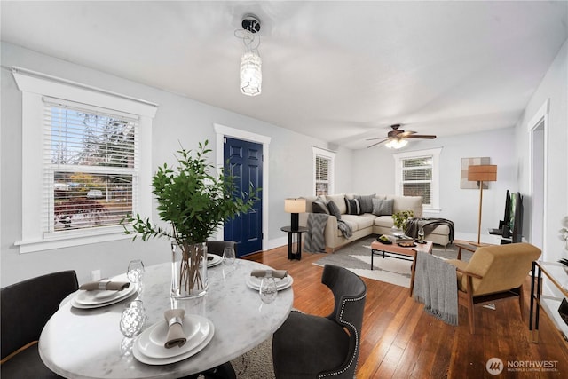 dining room featuring baseboards, hardwood / wood-style flooring, and a ceiling fan