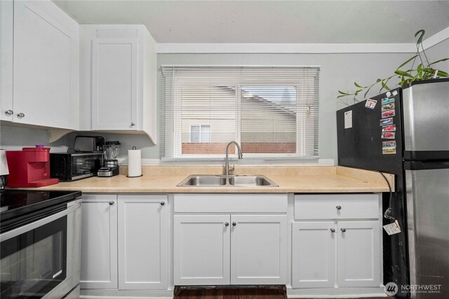 kitchen with white cabinetry, appliances with stainless steel finishes, light countertops, and a sink