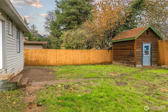 view of yard featuring an outbuilding, a shed, and a fenced backyard