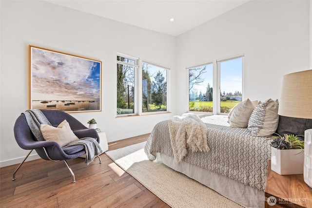 bedroom with baseboards, wood finished floors, and recessed lighting