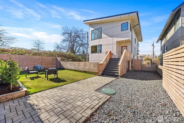 back of house featuring a patio, a yard, fence, and stucco siding