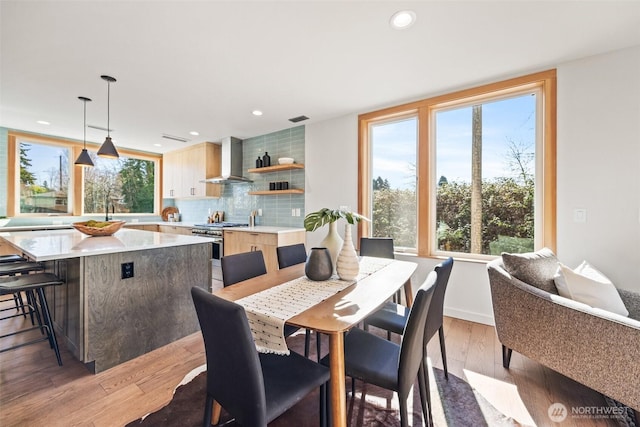 dining room with light wood-type flooring, visible vents, and recessed lighting