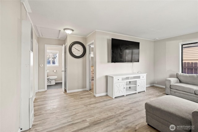 living room with light wood-style flooring, baseboards, and ornamental molding