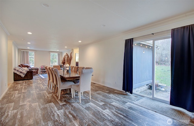 dining area with ornamental molding, baseboards, and wood finished floors