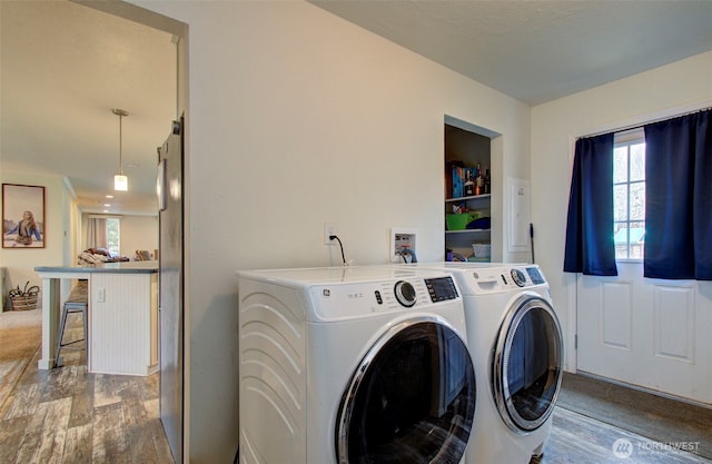 laundry area featuring laundry area, washing machine and clothes dryer, and wood finished floors