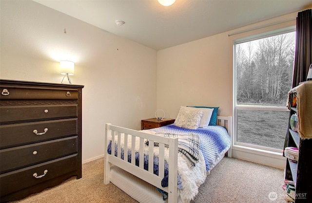 bedroom with light colored carpet and baseboards