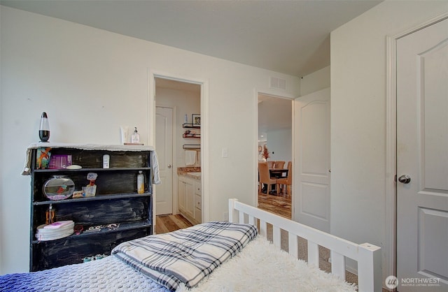 bedroom with visible vents and ensuite bathroom