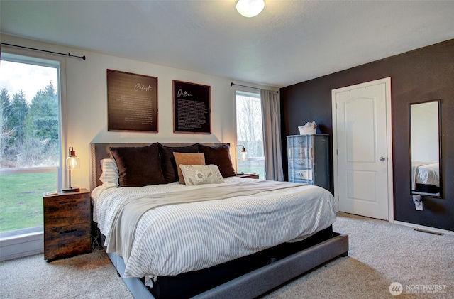 carpeted bedroom featuring multiple windows and visible vents