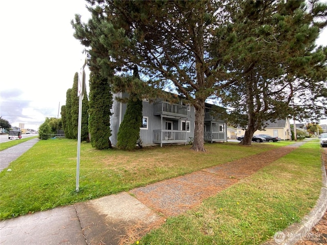 view of front of property featuring a front lawn and a balcony