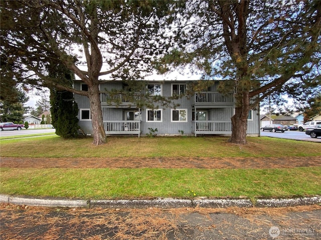 view of front facade featuring a front lawn and a balcony