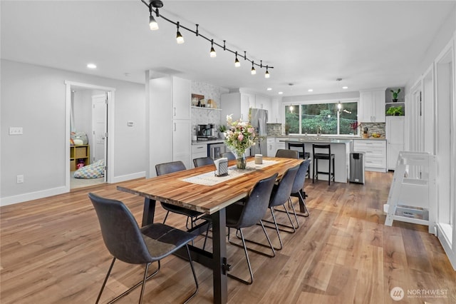 dining room featuring light wood finished floors, baseboards, and recessed lighting