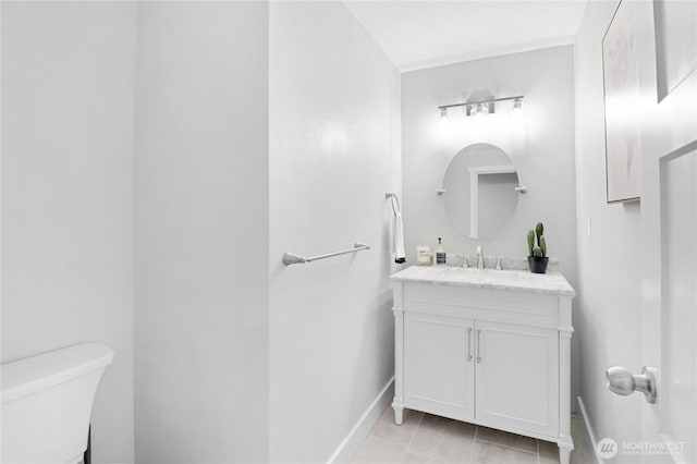 bathroom featuring tile patterned flooring, vanity, toilet, and baseboards