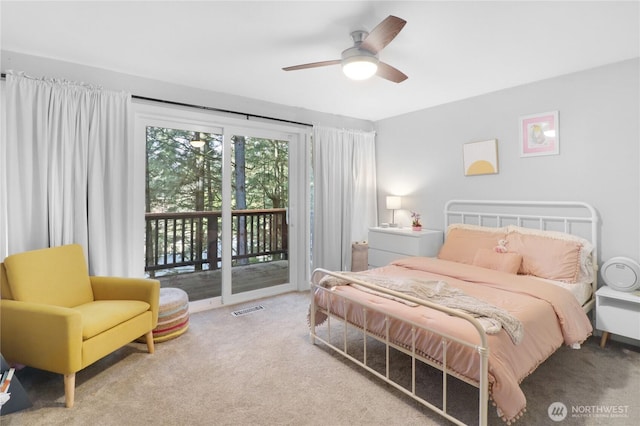 carpeted bedroom with access to exterior, visible vents, and a ceiling fan