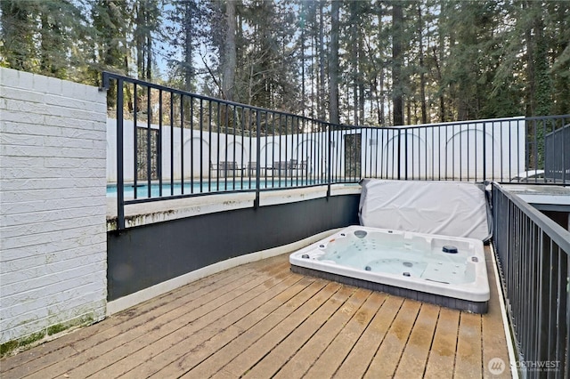 deck featuring a covered hot tub and a swimming pool