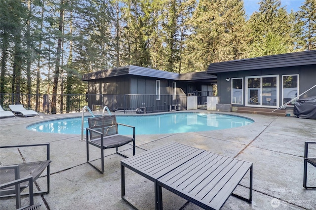 view of swimming pool featuring a patio area, fence, and a fenced in pool