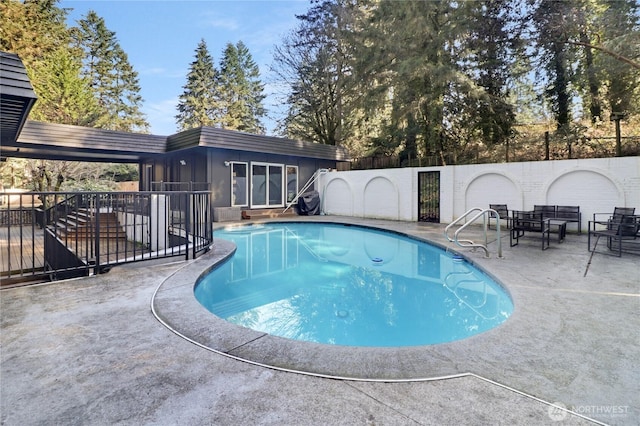 view of pool featuring a fenced in pool, an outbuilding, a storage structure, fence, and a patio area