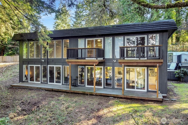 back of house featuring a sunroom and a balcony