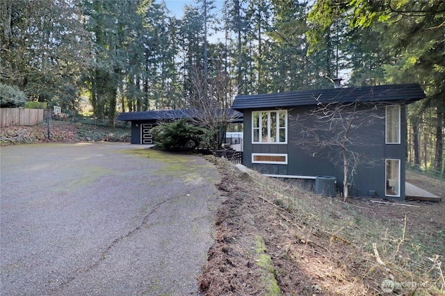 exterior space featuring driveway, fence, and central AC unit