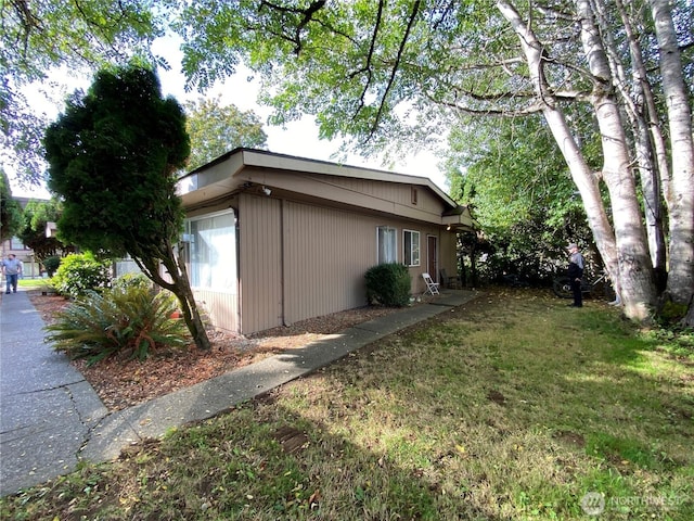 view of side of property with a yard and an attached garage