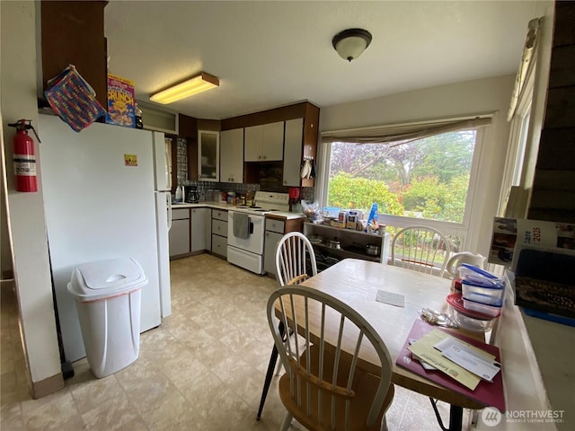 kitchen featuring white appliances, light countertops, backsplash, and light floors