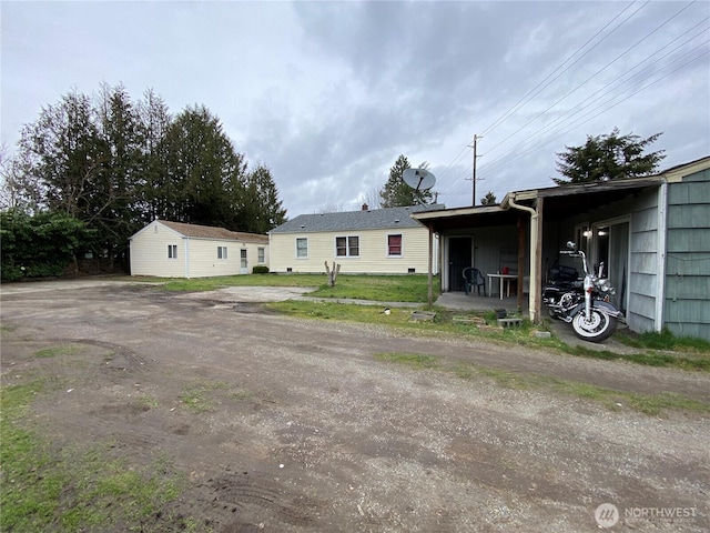 view of front of property featuring an outbuilding, driveway, and a carport