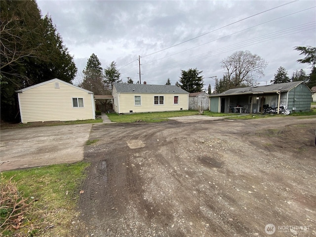 view of front of home featuring driveway and an outbuilding