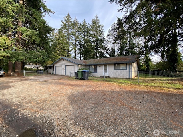 view of front of property featuring driveway, an attached garage, and fence