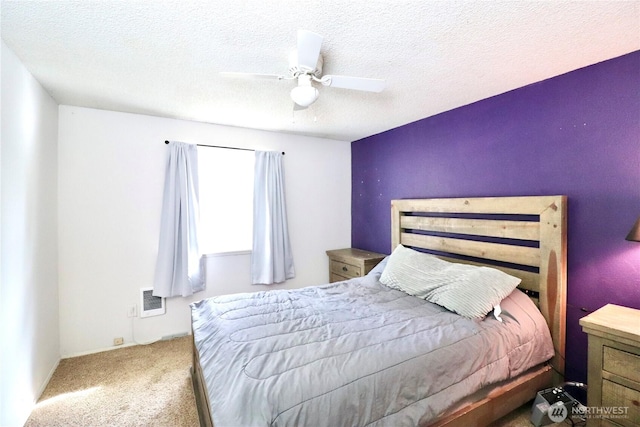 carpeted bedroom with a textured ceiling and a ceiling fan