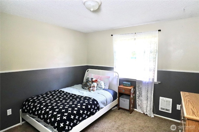 carpeted bedroom featuring a textured ceiling and visible vents