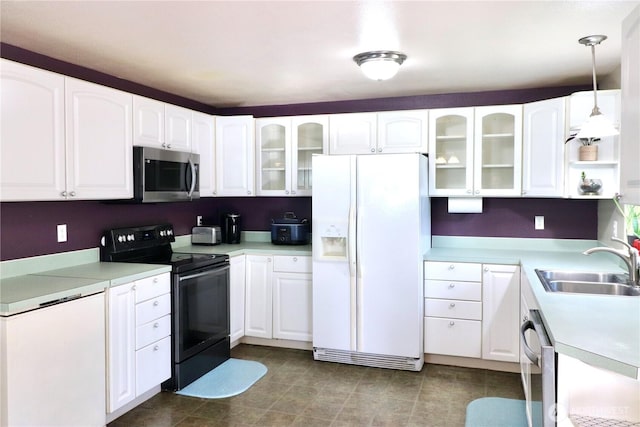 kitchen with stainless steel appliances, a sink, white cabinets, glass insert cabinets, and pendant lighting