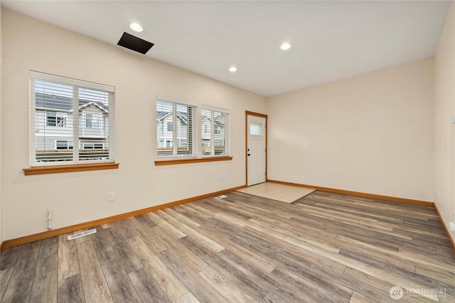 unfurnished room with baseboards, visible vents, wood finished floors, and recessed lighting